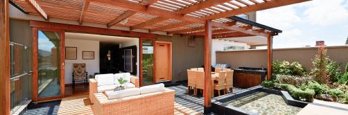 Eine Terrasse mit dunklen Holzelementen und einer großen Glasschiebetür